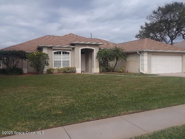 view of front of property with a garage and a front lawn