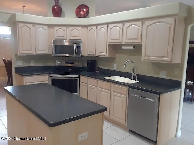 kitchen with light tile patterned floors, stainless steel appliances, a kitchen island, and sink