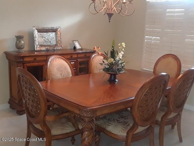 dining space featuring light tile patterned floors and an inviting chandelier