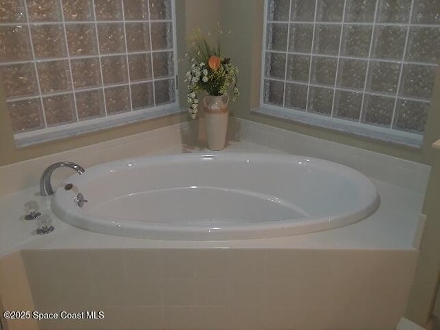 bathroom with a relaxing tiled tub