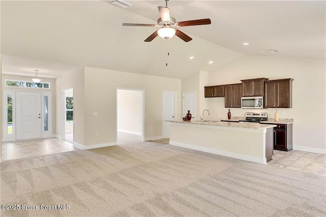 kitchen with light carpet, stainless steel appliances, sink, a kitchen island with sink, and ceiling fan