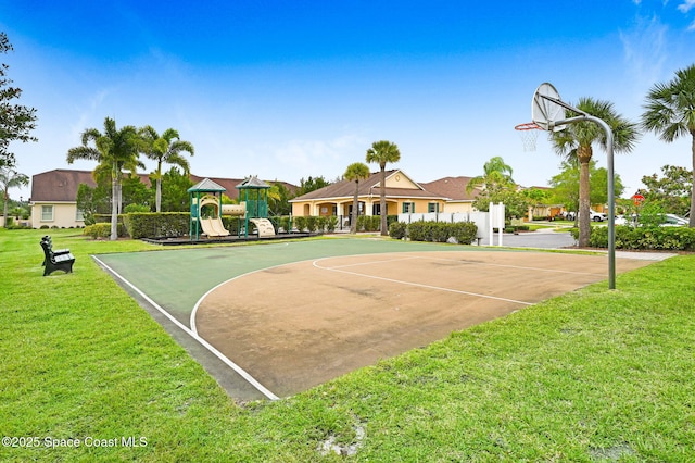 view of basketball court with a playground and a lawn