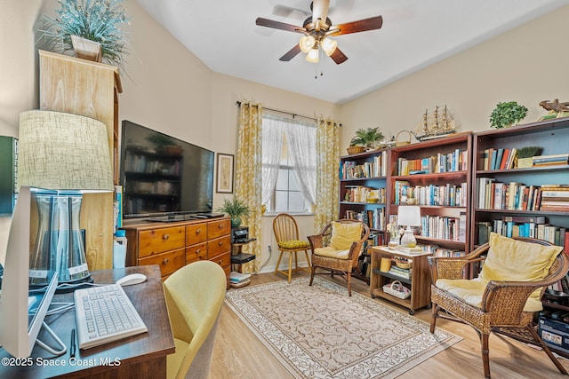 sitting room with ceiling fan and wood-type flooring