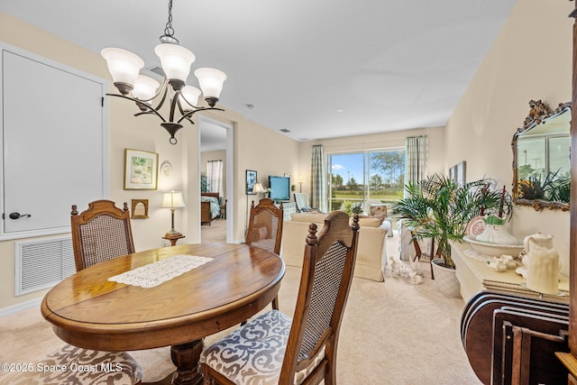 dining space featuring light colored carpet and a notable chandelier