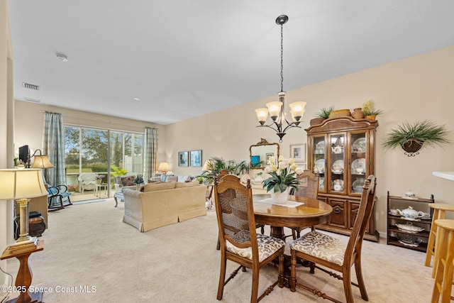 carpeted dining space with an inviting chandelier