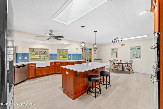 kitchen featuring a kitchen bar, sink, tasteful backsplash, black refrigerator with ice dispenser, and dishwasher