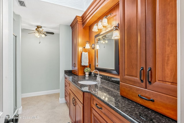 bathroom with tile patterned flooring, vanity, and ceiling fan