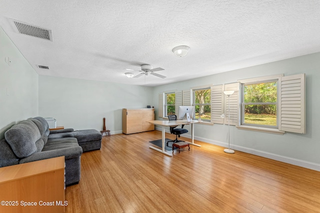 office space featuring ceiling fan, a textured ceiling, and light wood-type flooring