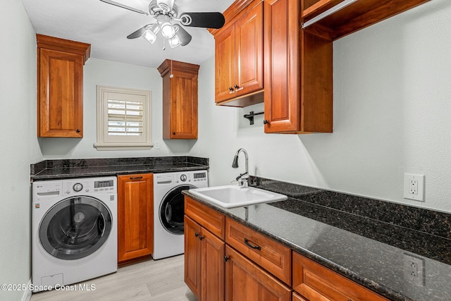 washroom with separate washer and dryer, sink, cabinets, ceiling fan, and light hardwood / wood-style flooring