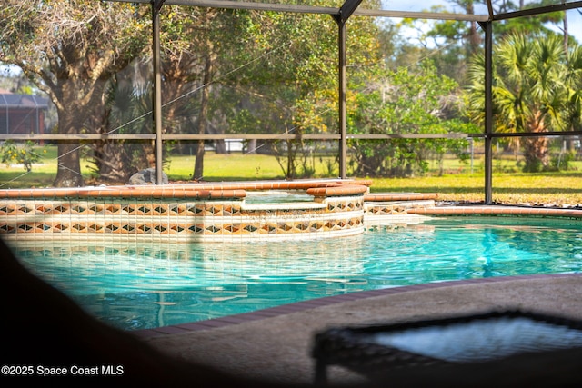 view of swimming pool with an in ground hot tub and a lanai