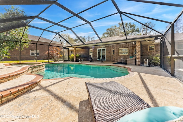 view of swimming pool with a patio area, ceiling fan, and glass enclosure