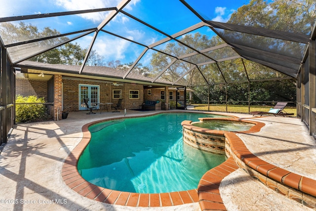 view of pool with an in ground hot tub, a patio area, glass enclosure, and french doors