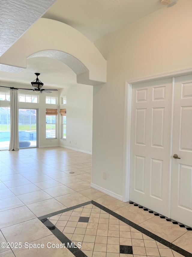 empty room featuring ceiling fan and light tile patterned floors