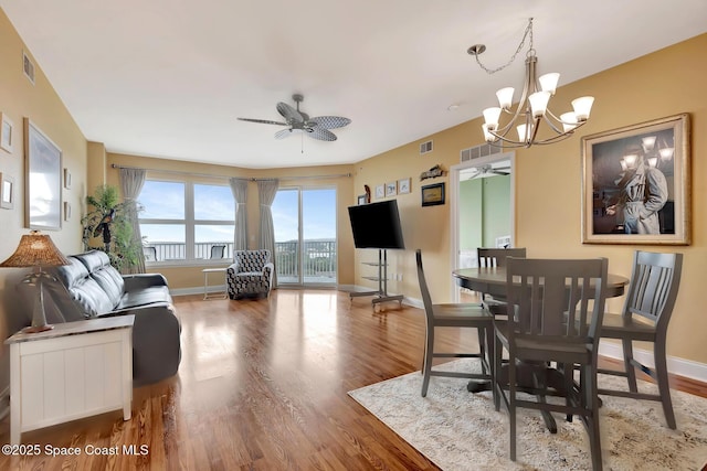 dining room featuring ceiling fan with notable chandelier and hardwood / wood-style flooring