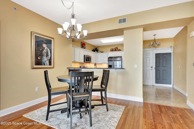 dining room featuring an inviting chandelier and light hardwood / wood-style floors