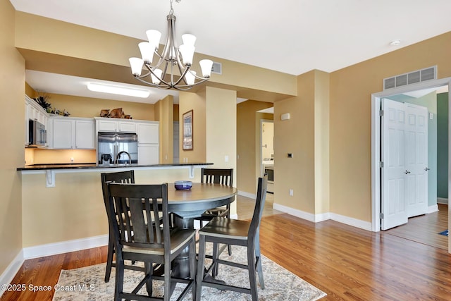 dining area featuring wood-type flooring and a chandelier