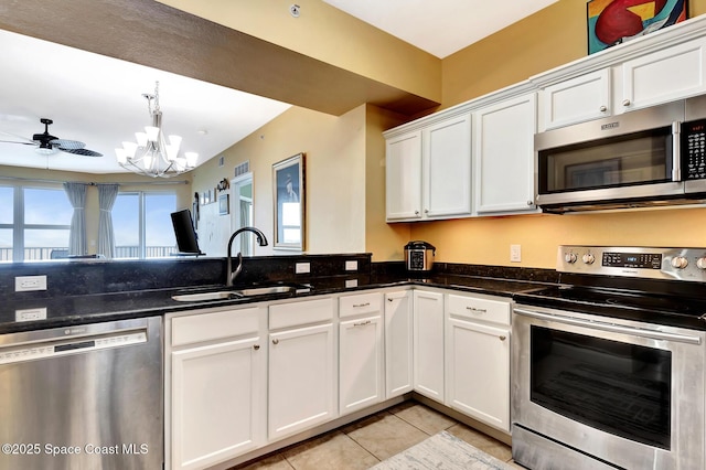 kitchen featuring white cabinetry, appliances with stainless steel finishes, sink, and dark stone countertops