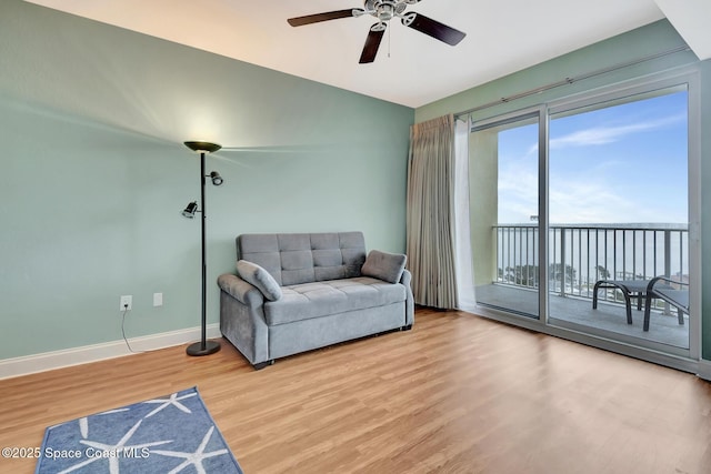 living area with lofted ceiling, ceiling fan, and light wood-type flooring