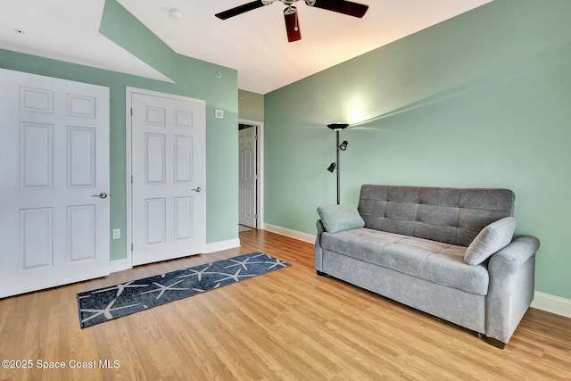 sitting room with ceiling fan and wood-type flooring