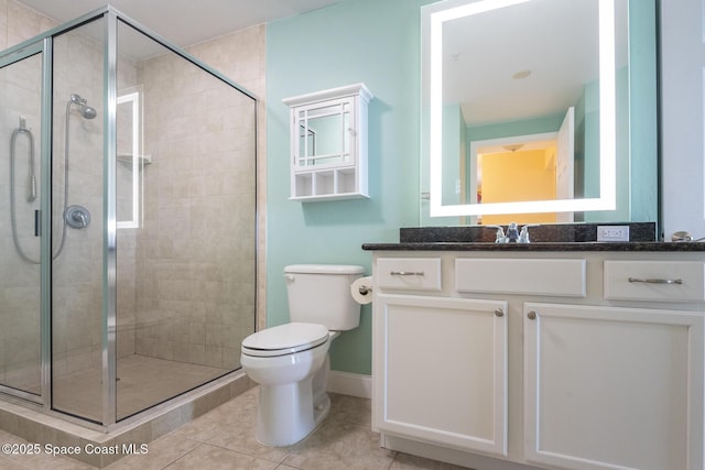 bathroom featuring vanity, toilet, tile patterned flooring, and a shower with door