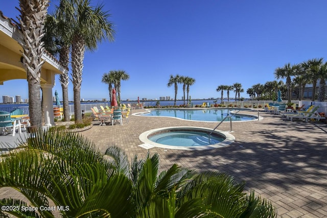 view of pool featuring a patio area, a community hot tub, and a water view