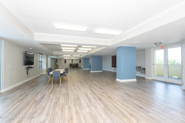 unfurnished dining area with a tray ceiling and light hardwood / wood-style floors