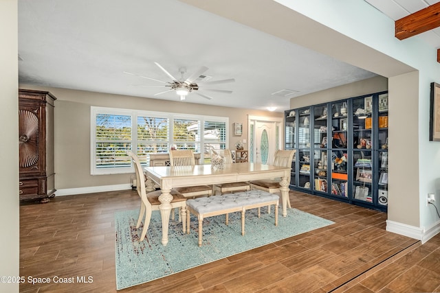 dining room with beam ceiling, dark hardwood / wood-style floors, and ceiling fan