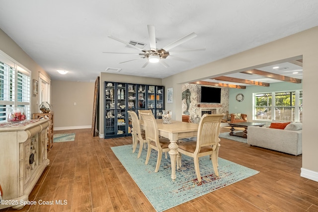 dining area with beam ceiling, light wood-type flooring, and a wealth of natural light