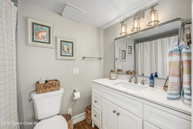 bathroom with vanity, hardwood / wood-style floors, walk in shower, and toilet