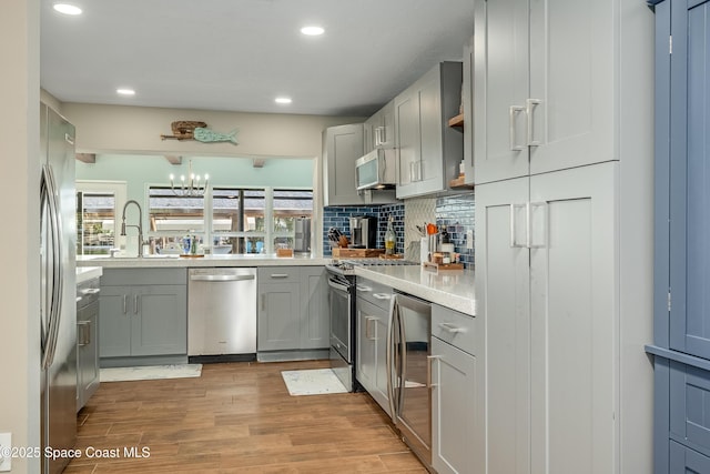 kitchen featuring gray cabinetry, appliances with stainless steel finishes, sink, and a wealth of natural light