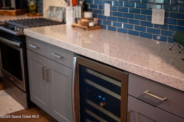 kitchen featuring wine cooler, stainless steel gas range, and gray cabinets