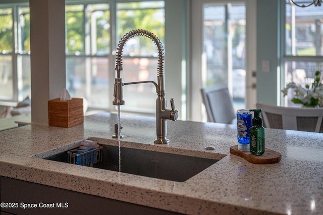 details featuring light stone counters and sink