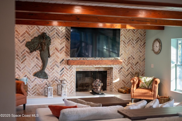 living room with a brick fireplace and beamed ceiling