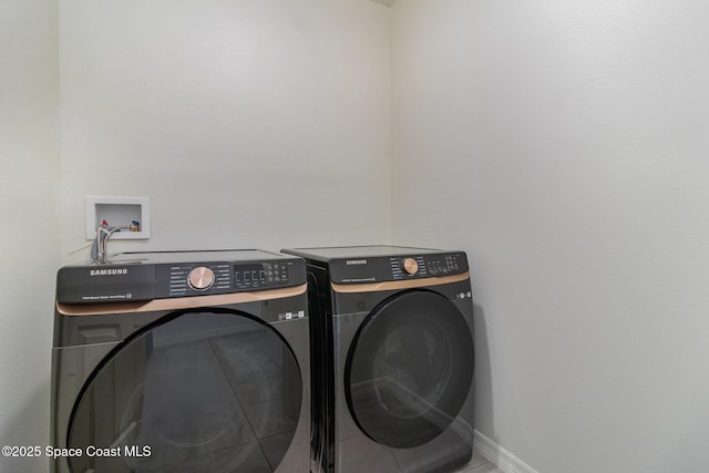 laundry area with laundry area, washer and clothes dryer, and baseboards