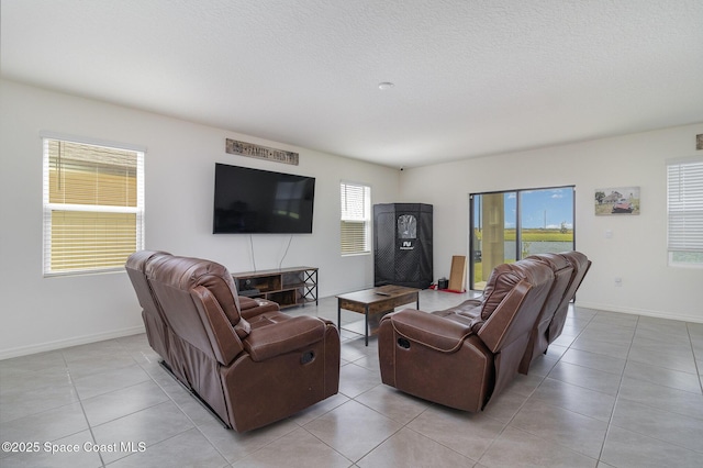 living area with light tile patterned floors, a textured ceiling, and baseboards