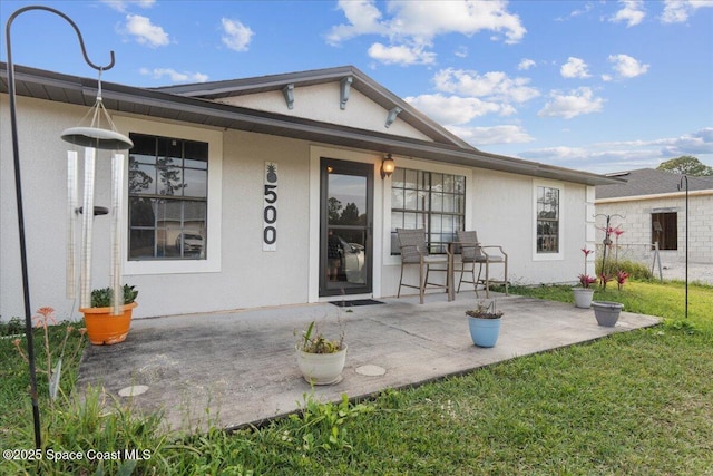 back of house with a patio area and a yard