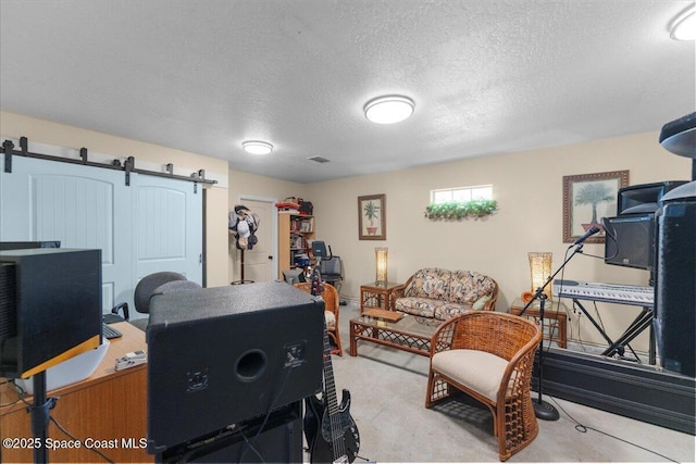 office with a barn door and a textured ceiling