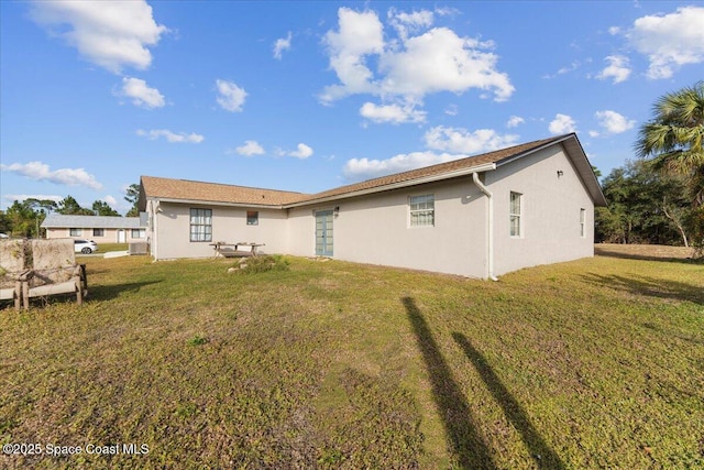 back of property featuring a lawn