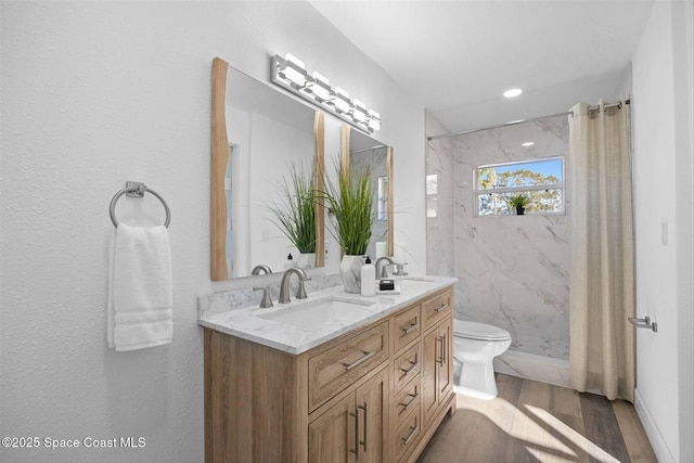 bathroom featuring hardwood / wood-style flooring, a shower, toilet, and vanity