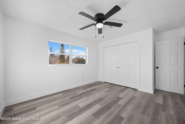 unfurnished bedroom with ceiling fan, a closet, and light wood-type flooring