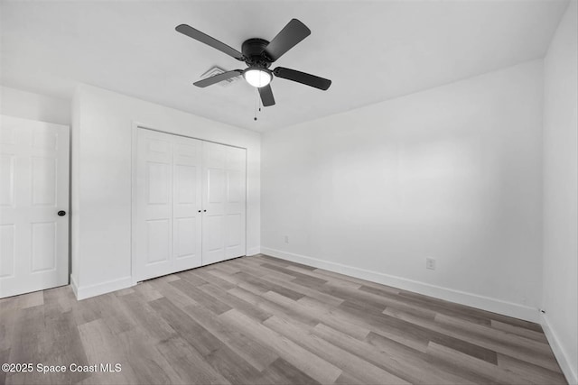 unfurnished bedroom featuring ceiling fan, a closet, and light hardwood / wood-style flooring