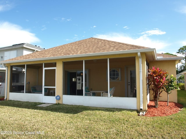 back of house featuring a yard and a sunroom