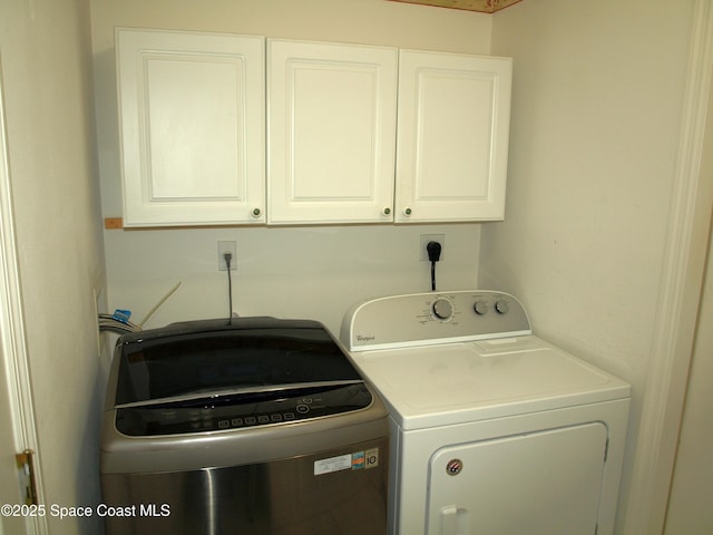 laundry area featuring washer and dryer and cabinets