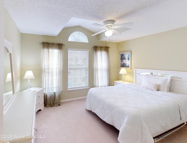 bedroom with light carpet, a textured ceiling, lofted ceiling, and ceiling fan