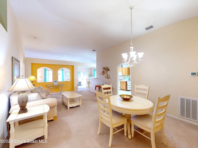 carpeted dining room featuring a notable chandelier