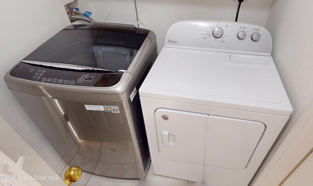 washroom with tile patterned flooring and washing machine and clothes dryer