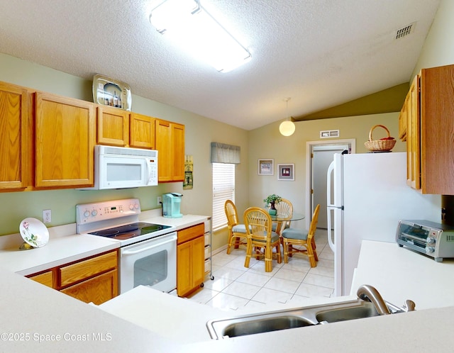 kitchen featuring sink, vaulted ceiling, a textured ceiling, pendant lighting, and white appliances