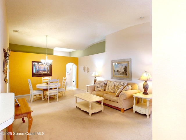 living room with lofted ceiling, carpet flooring, and an inviting chandelier