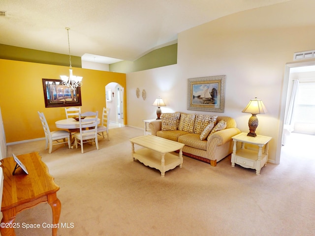 carpeted living room featuring lofted ceiling and a notable chandelier