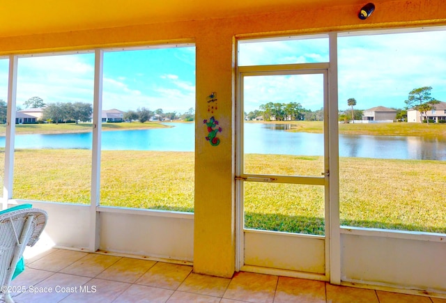 doorway featuring light tile patterned flooring and a water view